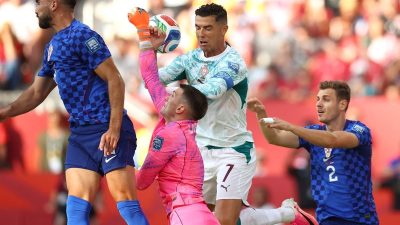Kiper Timnas Kroasia, Dominik Livakovic, menendang bola menjauh di samping penyerang Portugal, Cristiano Ronaldo, dalam pertandingan babak 32 besar Piala Dunia 2026 antara Portugal dan Kroasia di Stadion Toronto, Toronto, pada Jumat (3/7/2026) pagi WIB.(COLE BURSTON/AFP)