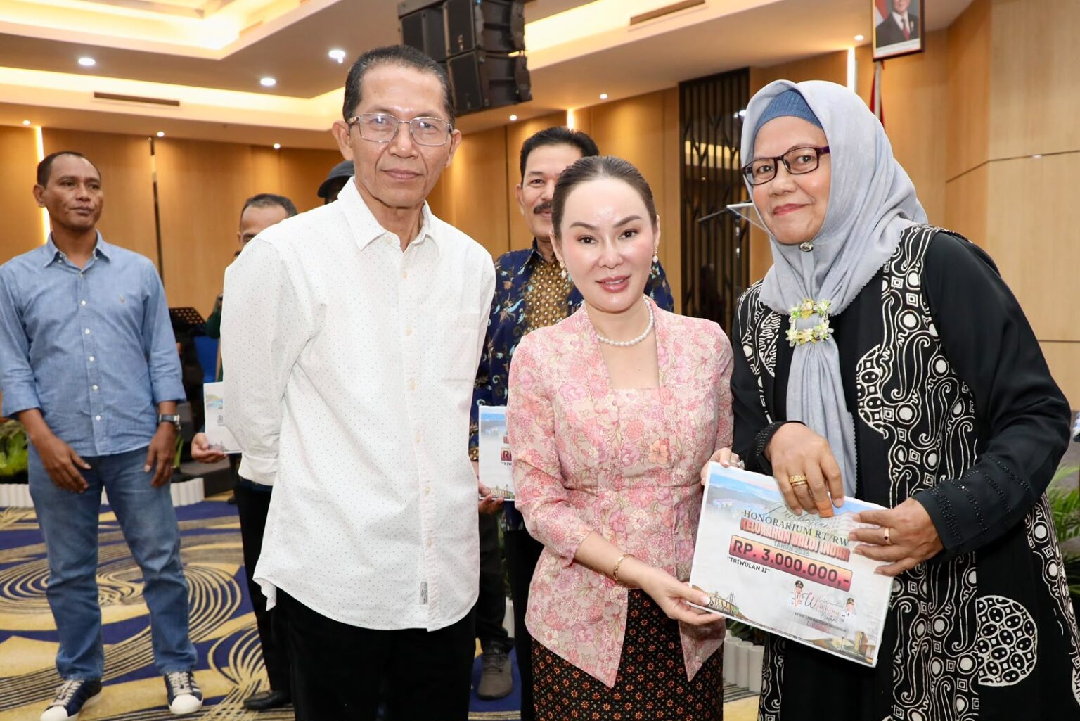 Wali Kota Batam, Amsakar Achmad, bersama Wakil Wali Kota Batam, Li Claudia Chandra, menyerahkan insentif RT,RW, dan LPM Lubukbaja di Hotel AP Premier, Senin (13/7/2026) malam. HUMAS DISKOMINFO BATAM
