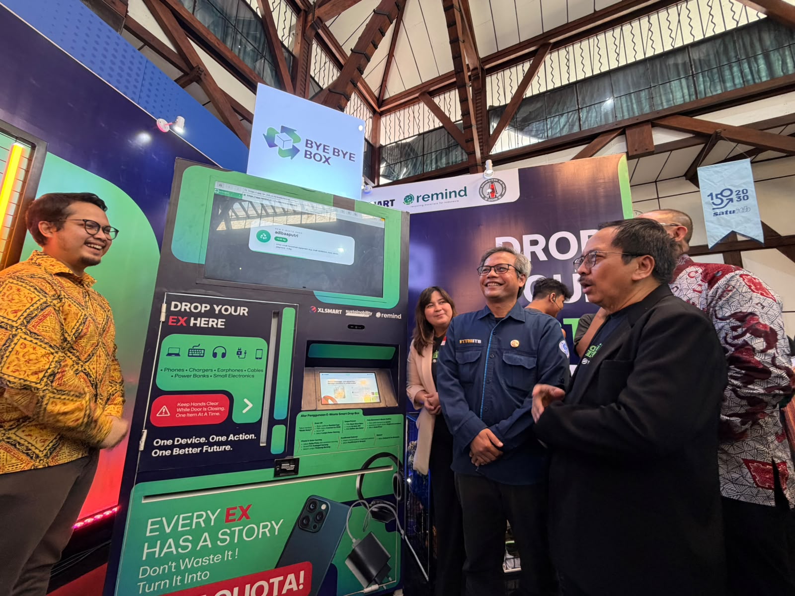 Founder & CEO REMIND, Muhammad Dzikri Ahira Soefihara (batik kuning) bersama dengan Direktur & Chief Regulatory Officer XLSMART, Merza Fachys (kanan), Dekan Fakultas Teknik Pertambangan dan Perminyakan ITB, Prof. Dr.Eng. Ir. Syafrizal, S.T., M.T.(tengah), Head Sustainability XLSMART, Ratu Maulia Ommaya (kiri) mencoba memindai salah satu perangkat elektronik tidak terpakai melalui vending machine #ByeByeBox dalam acara peluncuran Program E-Waste Reverse Vending Machine pertama di Indonesia “#ByeByeBox” di Aula Timur ITB Ganesha, Bandung. Senin (14/9).